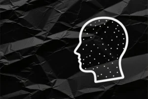 White dotted outline of a persons head places to the right of view. black matter paper background.