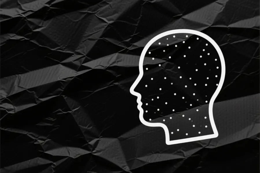 White dotted outline of a persons head places to the right of view. black matter paper background.